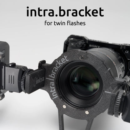 Camera with intra bracket for twin flashes on a light gray background